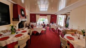 a dining room with white tables and chairs at Hôtel Saint Jacques in Thorigné-sur-Dué