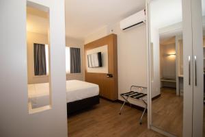 une petite chambre avec un lit et un miroir dans l'établissement Charmoso e central, à Brasilia 21 autres photos