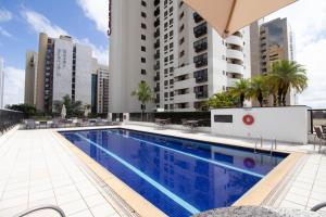 une piscine avec des bâtiments en arrière-plan dans l'établissement Charmoso e central, à Brasilia