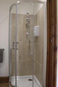 a shower with a glass door in a bathroom at Malthouse Farm Cottage Studio in Dilhorne