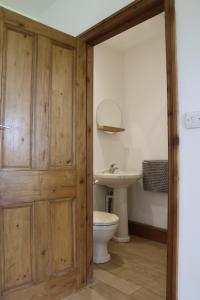 a bathroom with a toilet and a sink at Malthouse Farm Cottage Studio in Dilhorne