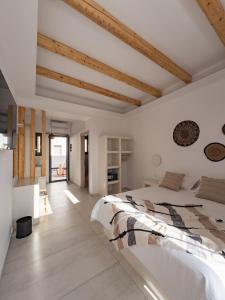 ein weißes Schlafzimmer mit einem großen Bett und Holzdecken in der Unterkunft Alonia Suites in Naoussa