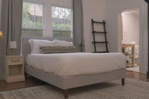Un dormitorio con una gran cama blanca y una ventana en Quaint Downtown Home Close to Everything en Lafayette