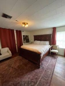 a bedroom with a bed and a chair and a window at Work Crew Haven: Spacious Corporate Lodging in Lafayette