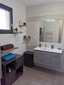 a bathroom with a sink and a mirror at Villa moderne, piscine privée Cruzy in Cruzy +14 photos