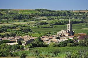 a small town with a church in the middle of a village at Villa moderne, piscine privée Cruzy in Cruzy