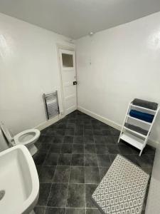 a bathroom with a sink and a toilet and a shelf at City Heights inquire for FREE Parking in Kent