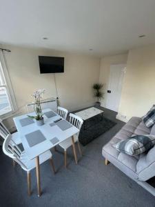 ein Wohnzimmer mit einem Tisch und einem Sofa in der Unterkunft City Heights inquire for FREE Parking in Kent