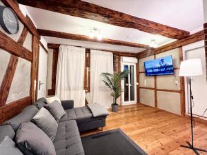 uma sala de estar com um sofá e uma televisão em BackHome - Fantastische Lage, SmartTV, Netflix, 50qm, 24h Checkin - Apartment 5 em Schwäbisch Hall