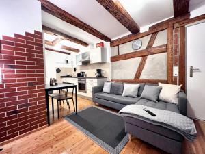 a living room with a couch and a brick wall at BackHome - Fantastische Lage, SmartTV, Netflix, 50qm, 24h Checkin - Apartment 5 in Schwäbisch Hall