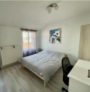 ein Schlafzimmer mit einem Bett und einem Stuhl darin in der Unterkunft Maison complète Normandie proche Giverny in Vernon