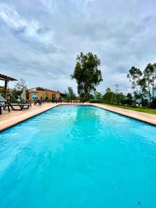 una gran piscina de agua azul en un patio en Cabaña en la Mesa de los Santos, en Piedecuesta