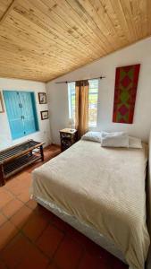 1 dormitorio con cama y techo de madera en Cabaña en la Mesa de los Santos, en Piedecuesta