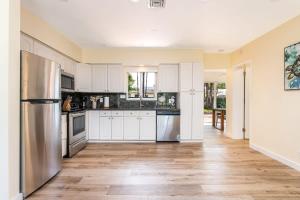 a kitchen with white cabinets and stainless steel appliances at Charming Multi Family 3 Bedroom with a Pool - Great Location in Dania Beach