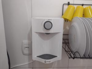 a white soap dispenser in the corner of a bathroom at Temporada Precisão Beta in Arraial do Cabo