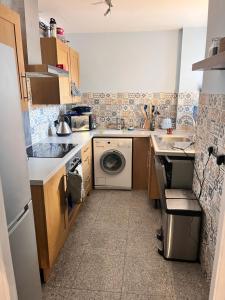 una pequeña cocina con lavadora y lavadora en Cozymodrenroom, en Brighton & Hove