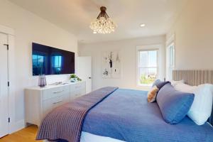 a bedroom with a blue bed and a chandelier at Oceans 12 in Wrightsville Beach