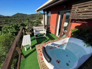 bañera de hidromasaje en una terraza con banco en Pousada Solar dos Lírios - Praia do Rosa en Praia do Rosa