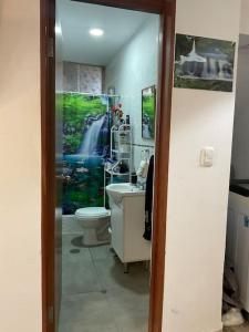 a bathroom with a waterfall painting on the wall at Disfruta de Mollendo in Mollendo