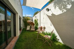 patio z krzesłami, stołem i parasolem w obiekcie Loft con piscina privada climatizada a 5' del Museo Dalí w mieście Figueres