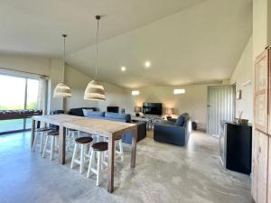 a dining room and living room with a table and chairs at La Casa da Pipa in Cesuras