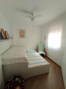 ein weißes Schlafzimmer mit einem Bett und einem Fenster in der Unterkunft Motril Carpe Diem Primera línea de playa in Motril