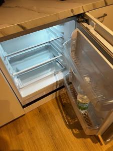 - un réfrigérateur vide avec une bouteille d'eau dans l'établissement cozy central apartment in the middle of Wiener Neustadt - RMI 2, à Wiener Neustadt