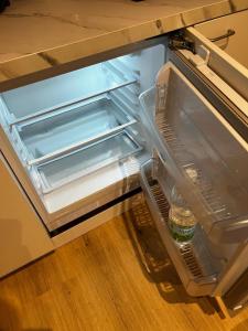 an empty refrigerator with a bottle of water in it at Innenstadtwohnung in Sackgasse mit Klima - RMI 2 in Wiener Neustadt