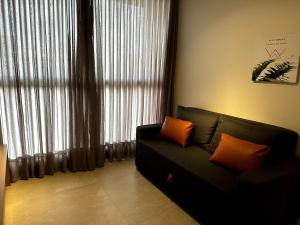 uma sala de estar com um sofá em frente a uma janela em PARK SUL - Edifício Essence - 10 em Brasília