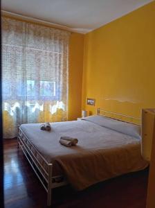 a yellow bedroom with two beds and a window at Luminoso appartamento - Castelli in Santa Maria delle Mole