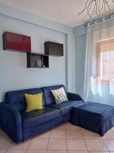 a blue couch with yellow pillows in a living room at Luminoso appartamento - Castelli in Santa Maria delle Mole
