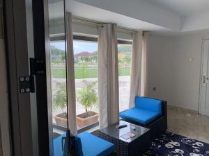 ein Wohnzimmer mit einem blauen Stuhl und einem Fenster in der Unterkunft HERITAGE LODGE & EVENT CENTER in Ada