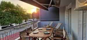 a balcony with a wooden table and chairs on it at Slanchev Apartment in Ofrínion