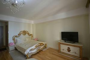 a bedroom with a bed and a flat screen tv at Hotel Park Studio Apartment Apolona in Ohrid