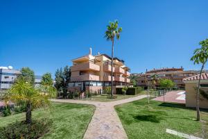 a building with palm trees in front of it at La Cala golf and Sun apartment in Mijas