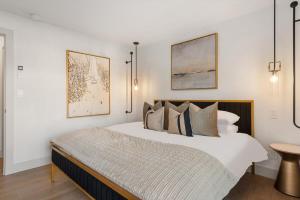 een witte slaapkamer met een groot bed met kussens bij New Listing Renovated 2 BR w AC in Aspen