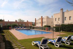 a swimming pool with lounge chairs in a yard at Hotur Via Augusta in Creixell
