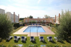 - une piscine avec des chaises longues et un groupe dans l'établissement Hotur Via Augusta, à Creixell