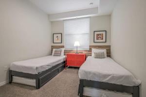 una camera con due letti e un comodino rosso di Superb Spacious Condo Prime Resort a Kissimmee Altre 29 foto