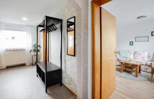 ein Wohnzimmer mit einem Spiegel und einem Sofa in der Unterkunft Ferienwohnung Spatzennest in Hellenhahn-Schellenberg