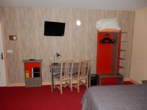 a bedroom with a bed and a desk and a tv at Hôtel Saint-Hubert in Cour-Cheverny
