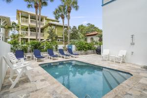 a swimming pool with chairs and a house at My Blue Heaven in Rosemary Beach