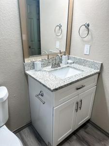 a bathroom with a sink and a mirror at Warm Cozy Hideaway Texas City 1 Bed Flat in Texas City