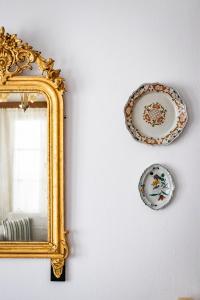 two plates and a mirror on a wall at Sofia's House - Skopelos Town in Skopelos Town