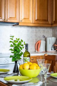 a table with a bowl of lemons and a bottle of wine at Sofia's House - Skopelos Town in Skopelos Town +22 photos