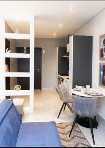 ein Wohnzimmer mit einem blauen Sofa und einem Tisch in der Unterkunft Luxury Studio Apartment in Accra