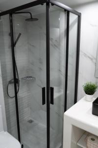 a shower with glass doors in a bathroom at CozyLoft 2 in Patra