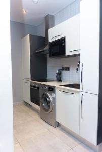 eine Küche mit einem Kühlschrank und einer Waschmaschine in der Unterkunft Luxury Studio Apartment in Accra