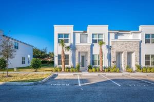 una casa blanca con palmeras en un aparcamiento en Spacious New Modern Retreat, en Orlando