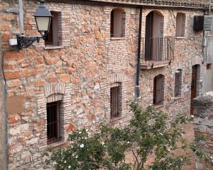 een oud stenen gebouw met ramen en een straatlicht bij Casa de La Serra in Montblanc